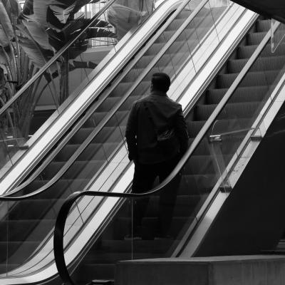Joven subiendo por las escaleras mecánicas.